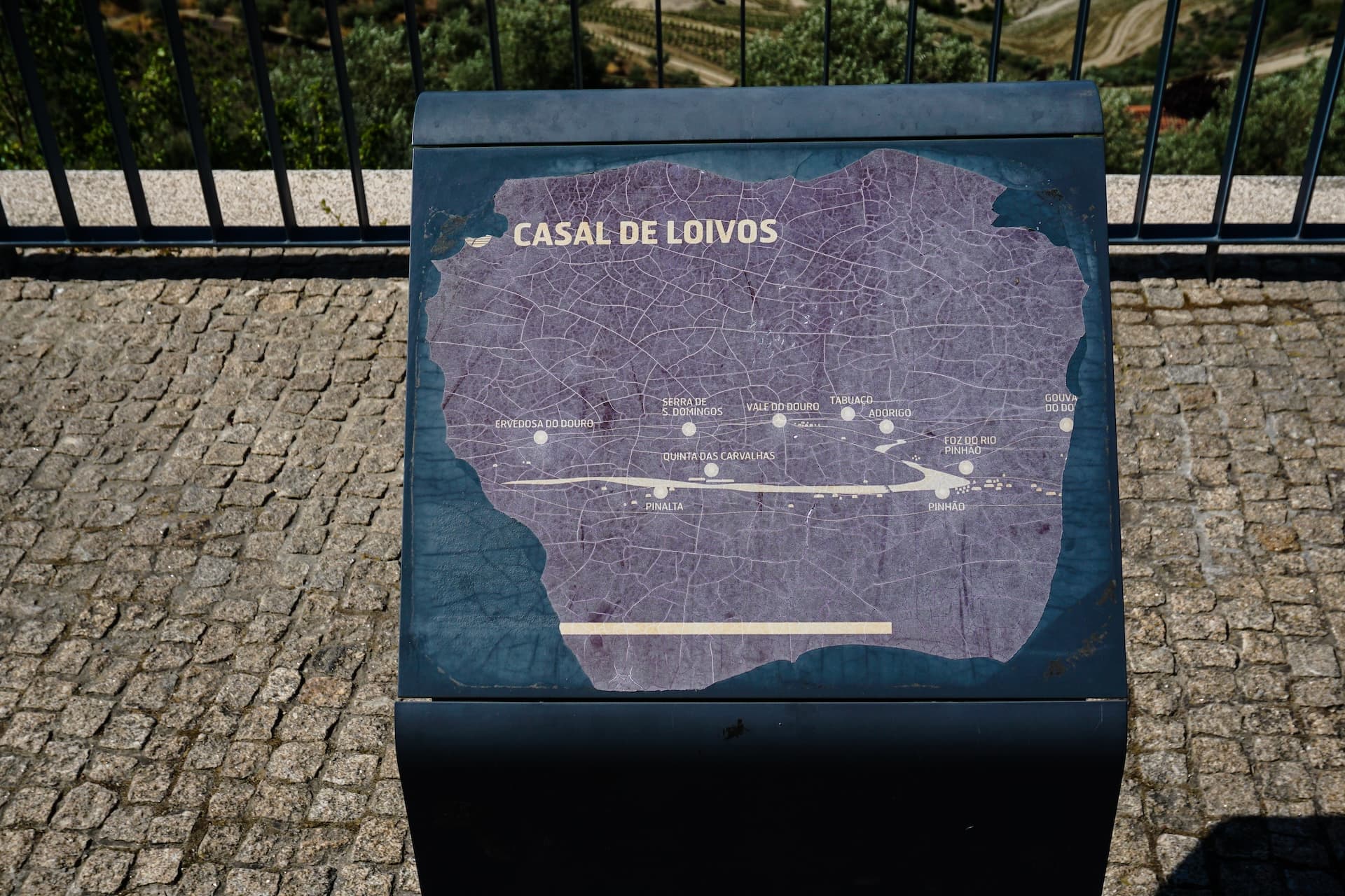 Information sign with a map titled "Casal de Loivos" on a cobblestone viewpoint in Portugal.