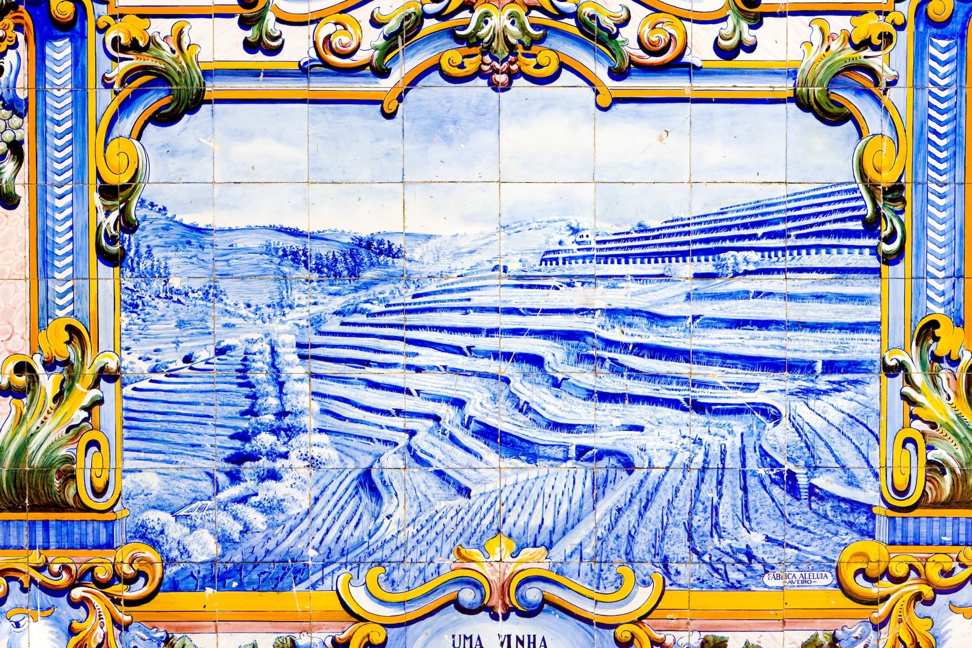 Azulejo tile mural showing terraced vineyards and buildings at the railway station of Pinhão, Douro Valley, Portugal.
