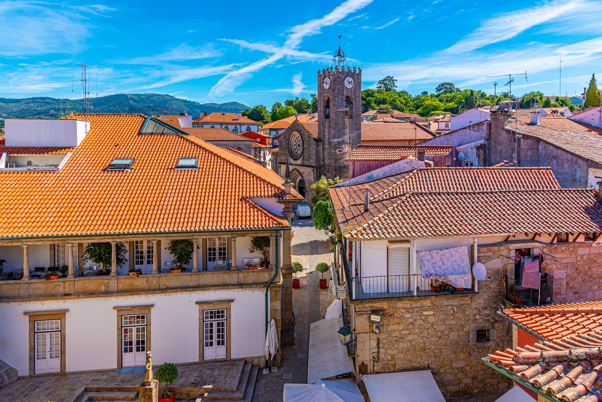 Aerial view of Ponte de Lima in Portugal with terracotta roofs and a stone clock tower.