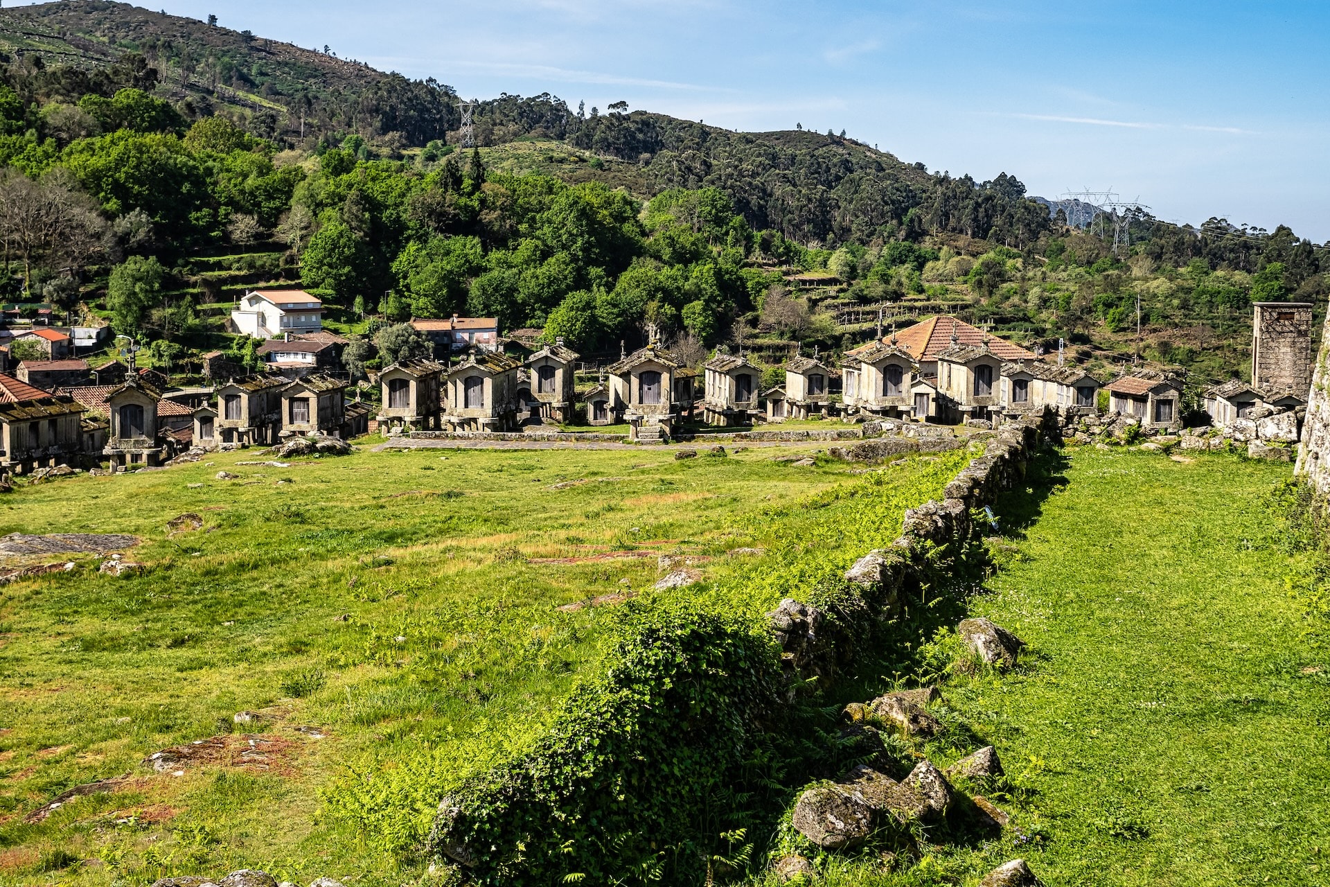Espigueiros stone granaries in the village of Lindoso, Peneda-National Park, with green hills.