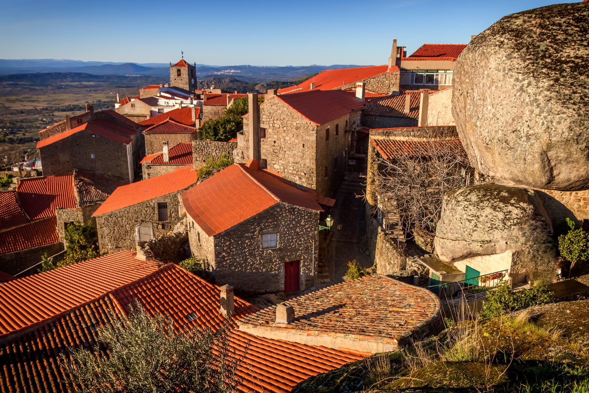 Stone village houses with red tile roofs built into a hillside in Soajo, Peneda-Gerês National Park, Portugal.