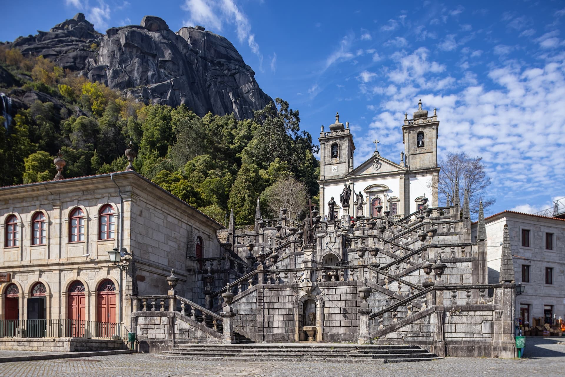 Sanctuary of Our Lady of Peneda church with grand stone staircase against a rocky mountain.