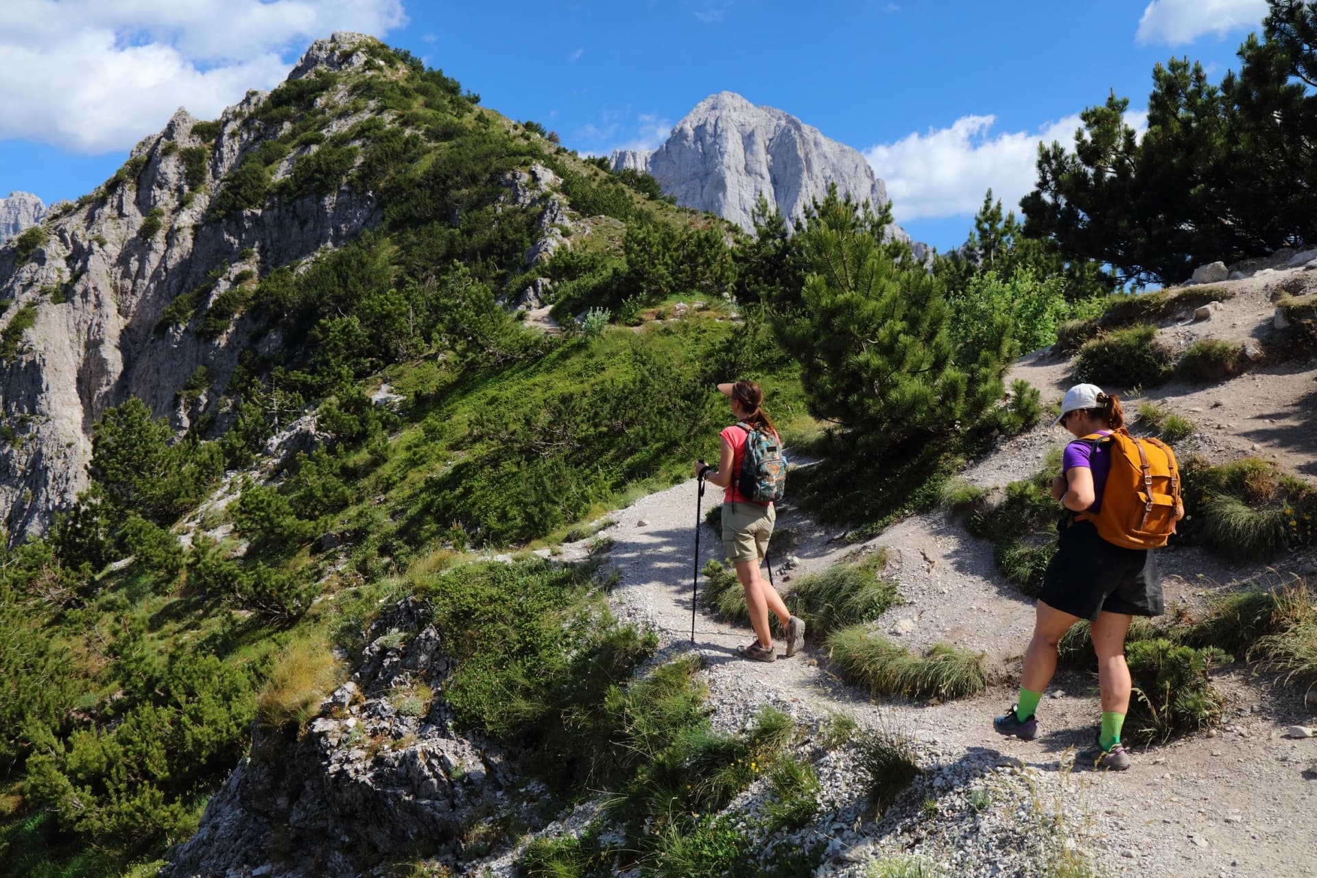 Women tourists hiking in sunny weather in Theth Mountains in Albanian Alps (also known as Accursed Mountains). Alps of Albania National Park.