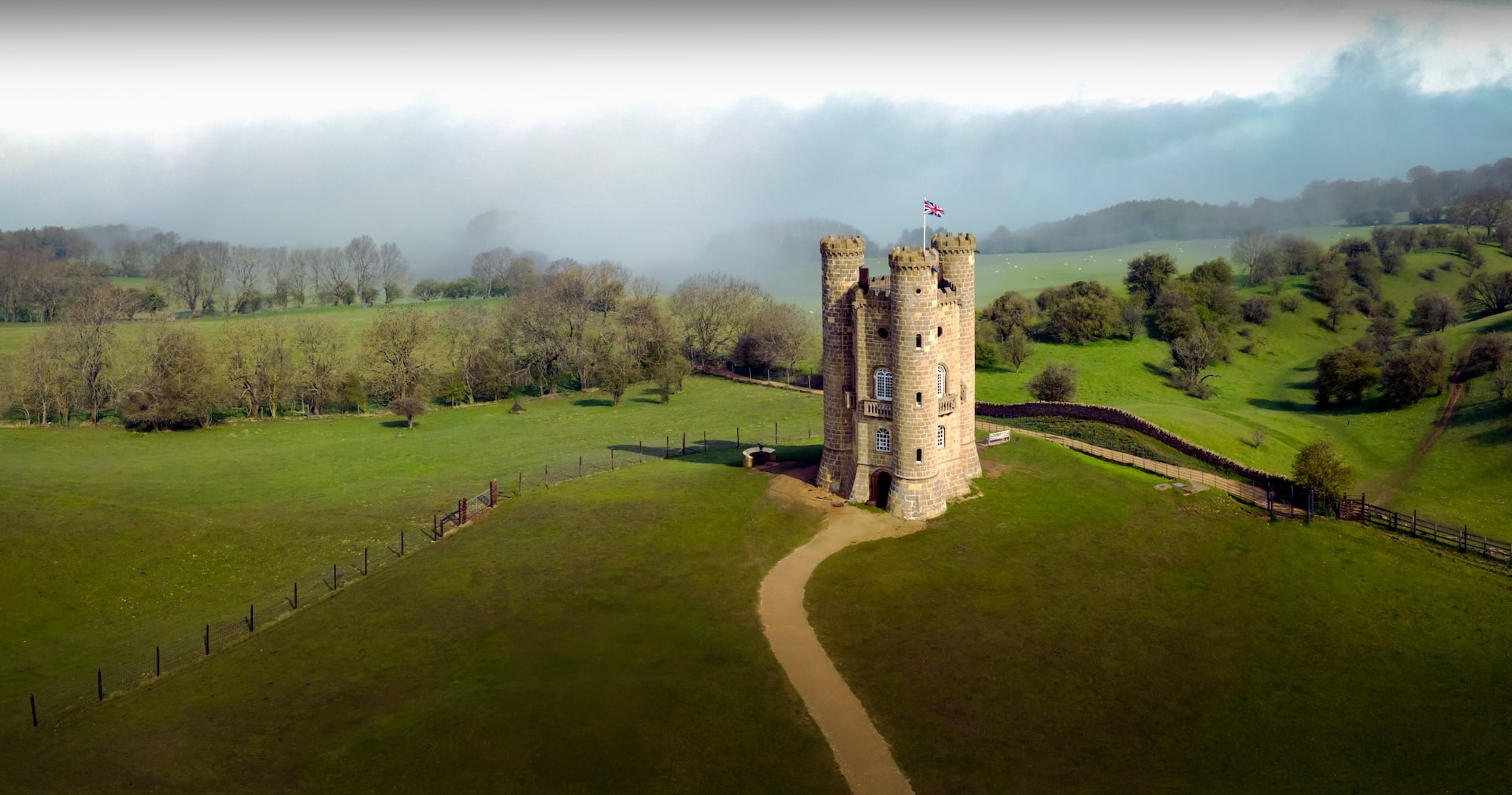 Broadway Tower on its hill with a path leading across the grass