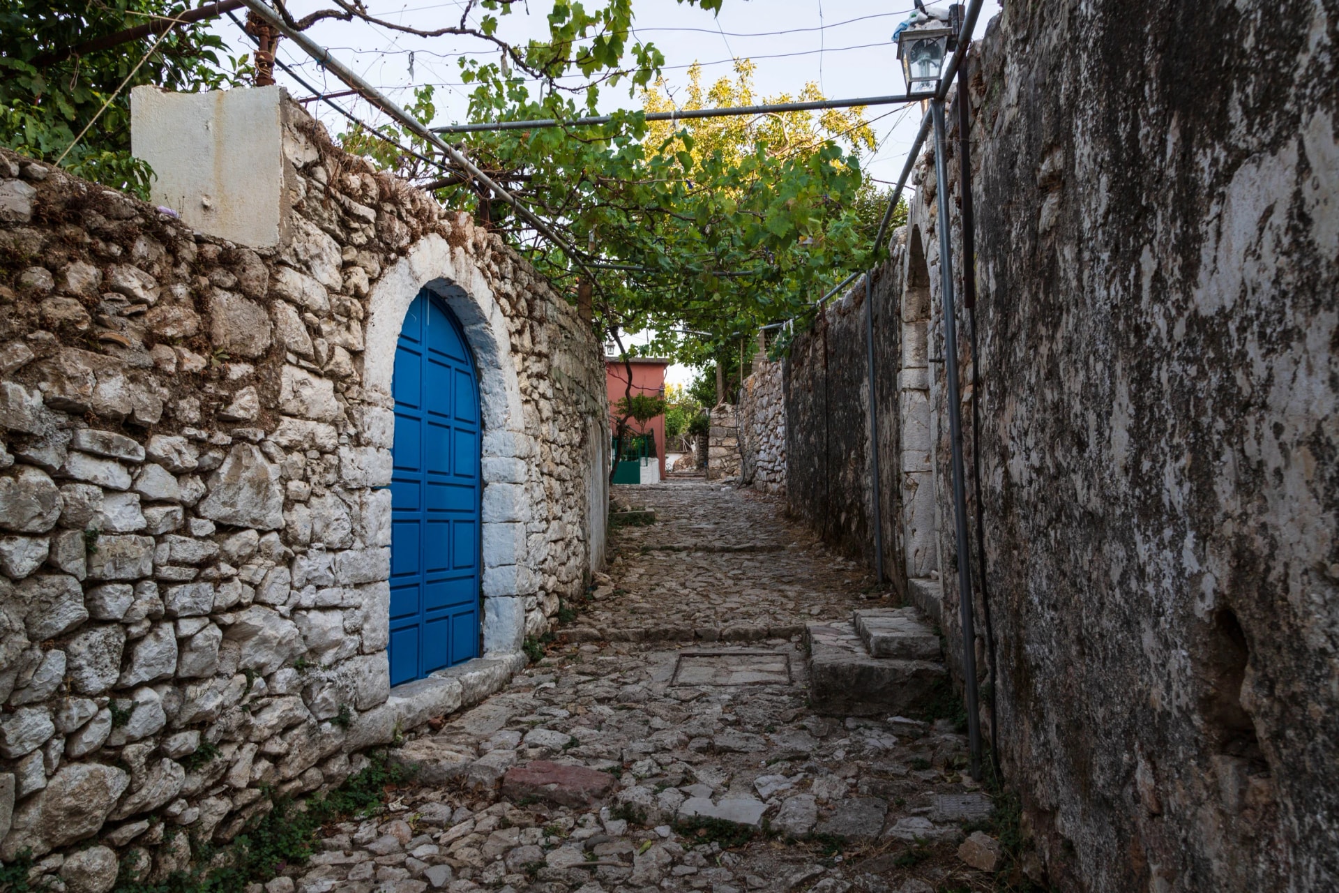 Classic traditional Mediterranean village house door and rock pavement Mediterranean style. picture taken in Albanian city of Himara the old part. Blue doors and roads in the village. Albania