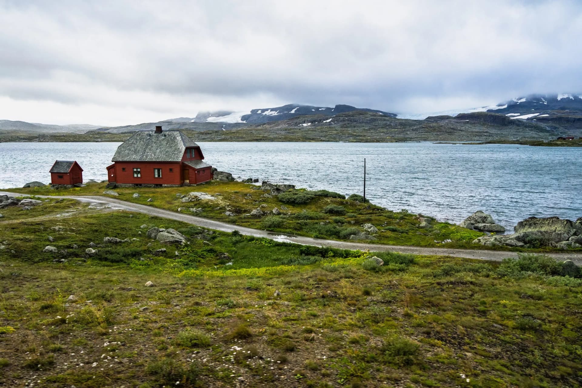 An isolated house on a lake in Hardangervidda National Park near Finse, Norway. Photo taken from Oslo-Bergen train, one of the most spectacular European railways