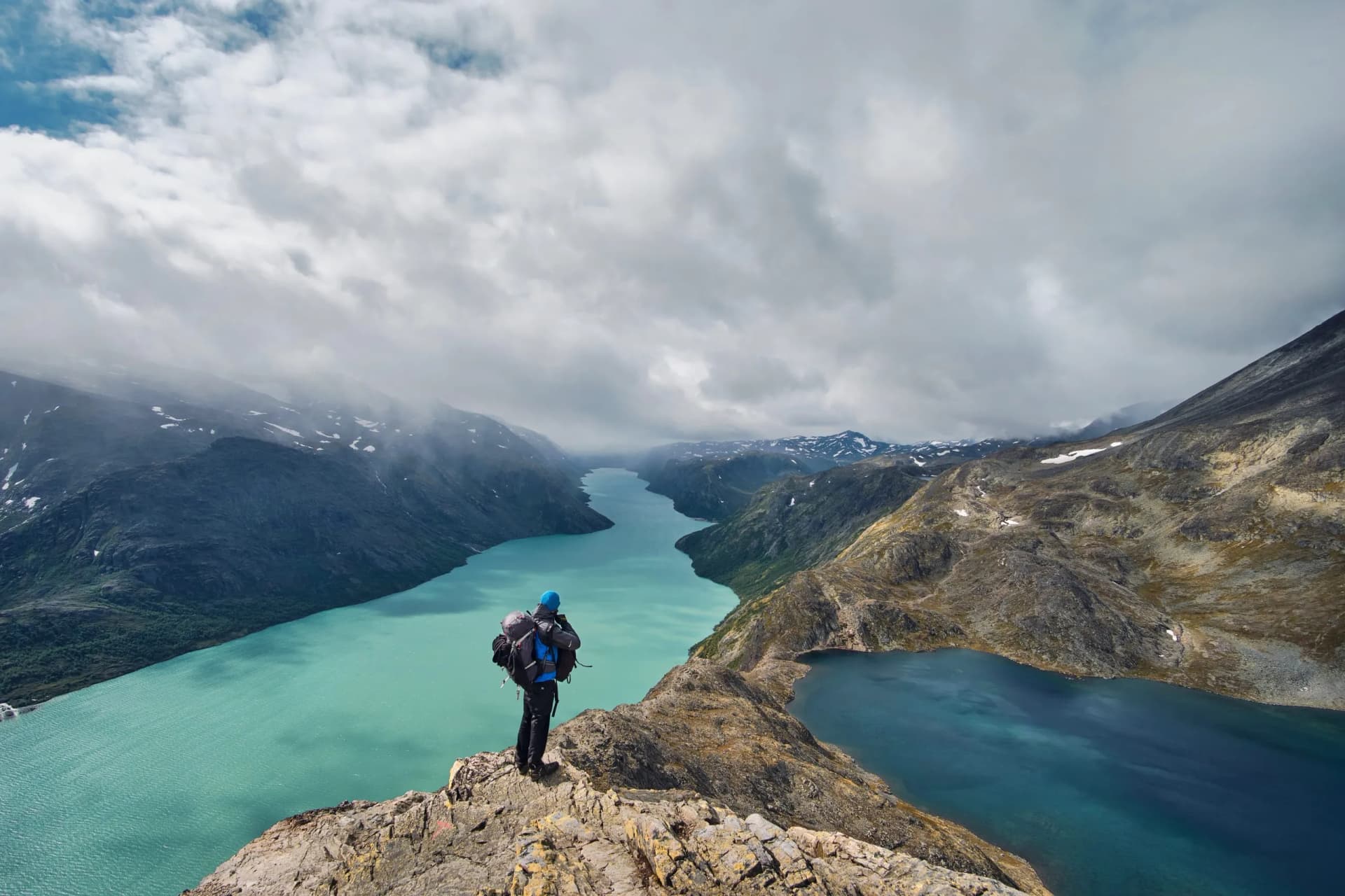 young hiker with backpack enjoy the wiev of besseggen ridge, gjende lake in the Jotunheimen national park norawy mountains