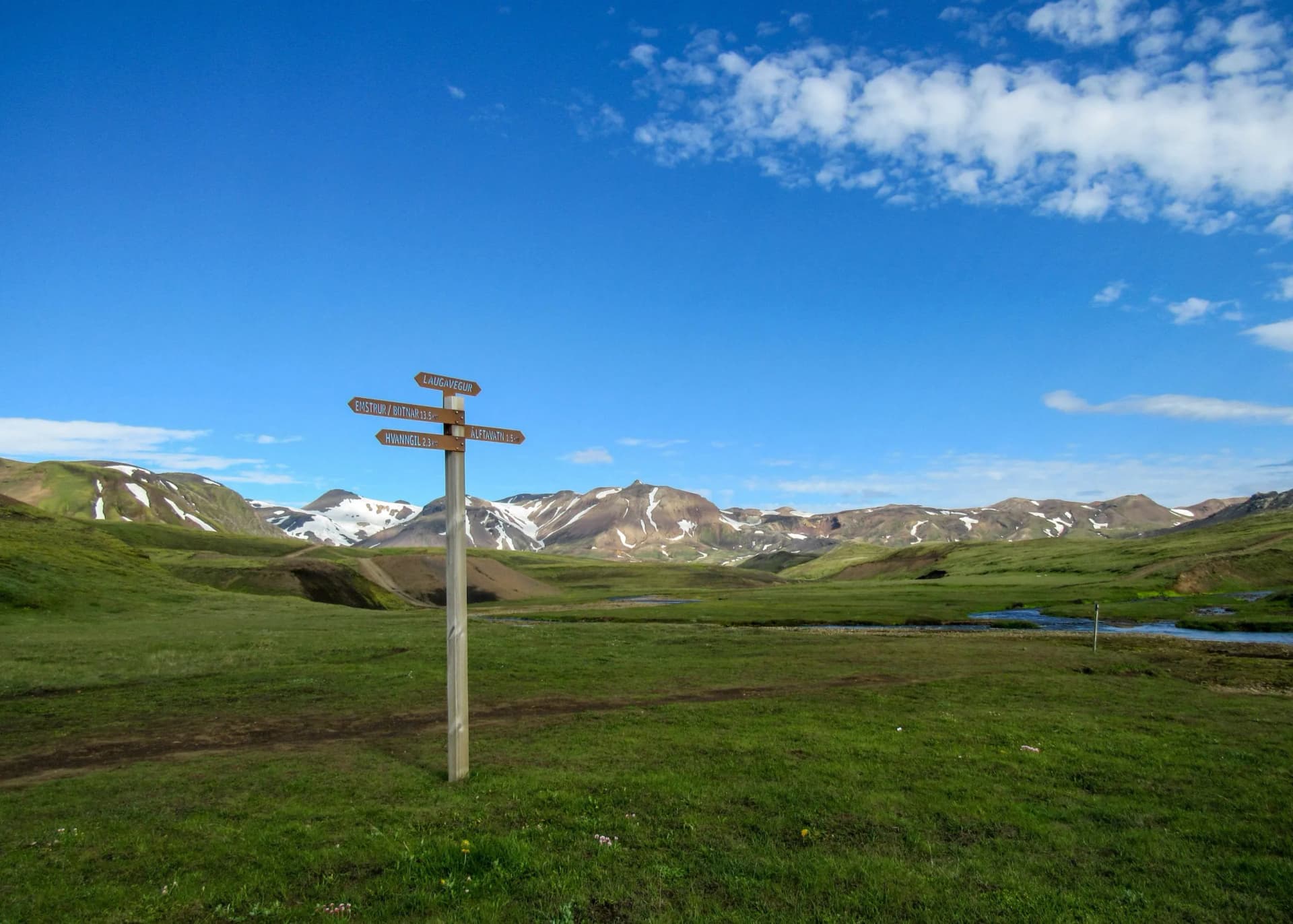 Hiking trail marker signpost on Laugavegur trail with directions to Emstrur/Botnar and mountains.