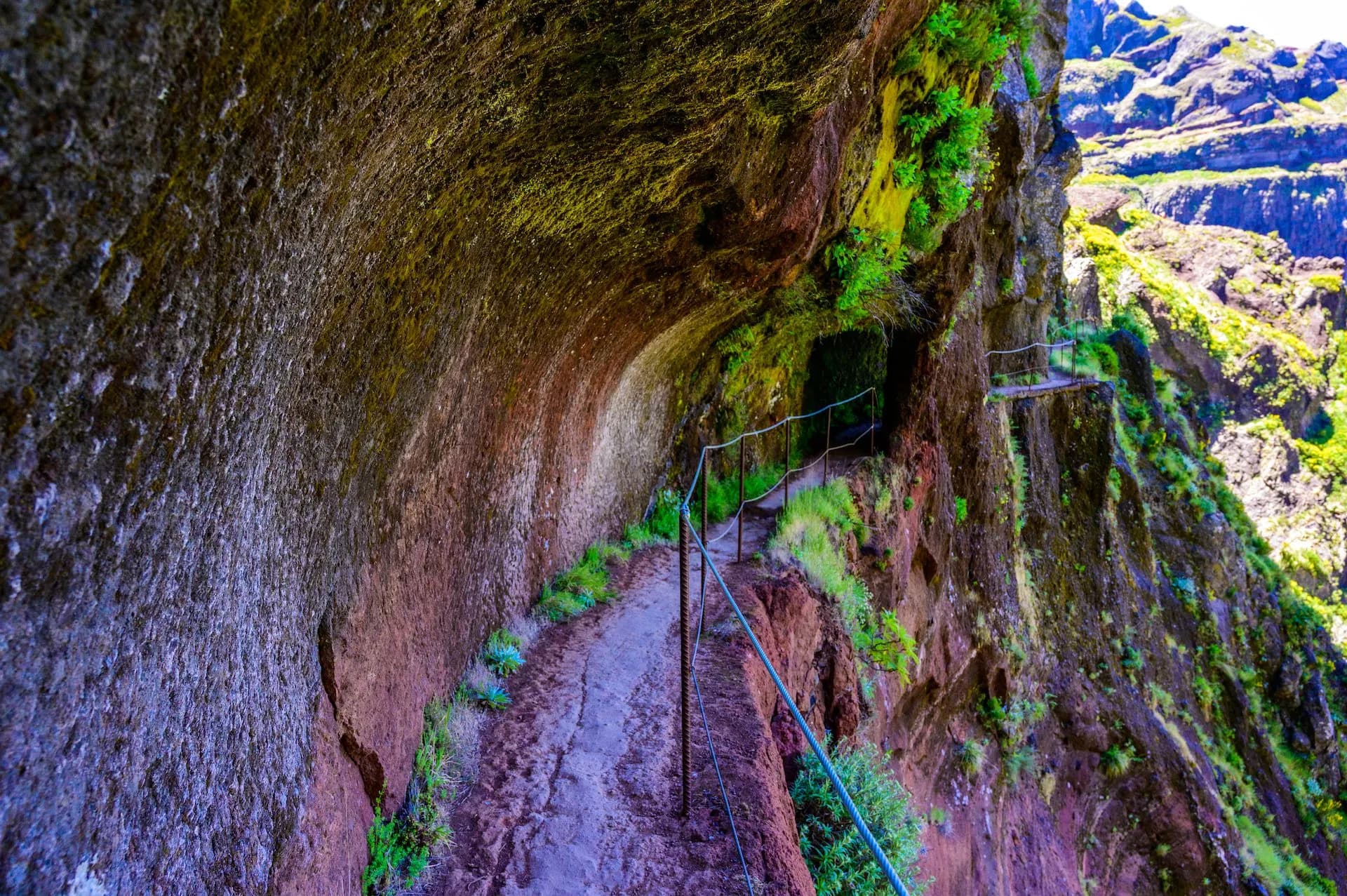 Hiking path carved into a cliff face between Pico do Arieiro and Pico Ruivo with steep drops.