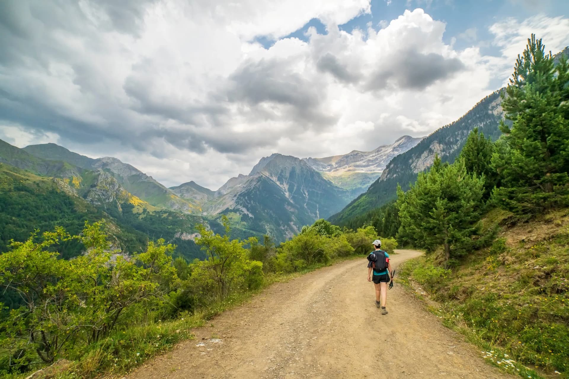 Female hiker going down to the Bujaruelo valley in a day with gray clouds, Ordesa y Monte Perdido national park.